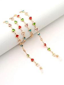 Détail de la chaîne de lunettes dorée avec cristaux de cœur colorés et embouts ajustables
