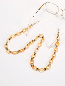 Détail de la chaîne à lunettes en acrylique ambré et maillons dorés avec boucles silicone