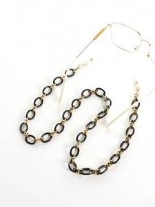 Détail de la chaîne en acrylique noir et métal doré avec boucles en silicone