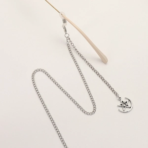 Silver punk glasses chain with star and moon charms on a minimalist background
