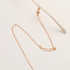 Chaîne de lunettes dorée tendance avec pendentifs ailes évidés et boucles de fixation