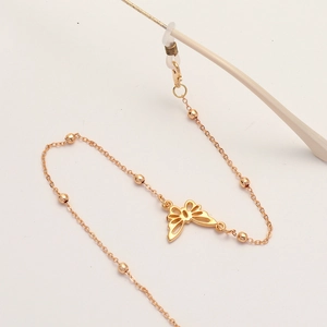 Gold glasses chain with hollow butterfly pendants and metal beads on a creamy background