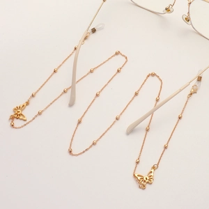 Golden eyewear chain with cutout butterfly charms and small beads on minimalist metal link