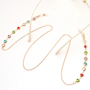Close-up of gold chain eyewear leash featuring colorful heart-shaped crystal charms