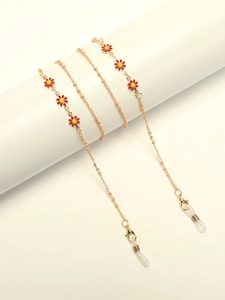 Detailed shot of golden eyewear chain with red daisy charms and silicone loop connectors