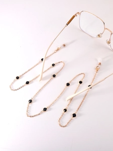 Golden eyeglass chain with black beads and silicone loops on gold frame glasses