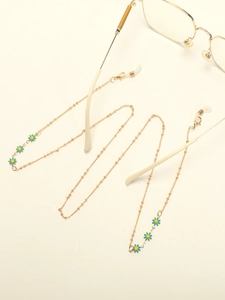 Detail of golden glasses chain featuring blue enamel daisy charms and silicone loops