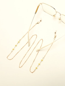 Detailed close-up of golden glasses chain with delicate white daisy floral accents