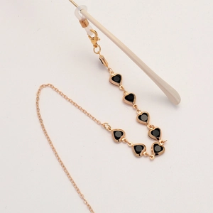 Golden chain eyewear strap featuring black heart pendants and adjustable silicone loops