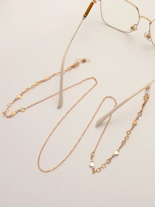 Golden eyewear chain with hollow stars and purple beads on white background