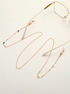 Golden sunglasses chain with colorful daisy charms and crystal beads on white background