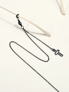 Chaîne de lunettes noire minimaliste avec pendentif croix et boucles en silicone sur fond beige