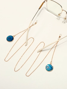 Chaîne à lunettes dorée avec pendentifs émaillés ciel étoilé bleu et boucles en silicone