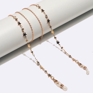 Catena per occhiali in oro rosa con stelle nere e strass su supporto minimalista bianco