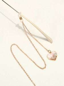 Golden eyewear chain with pink heart pendant and white pearls on beige sunglasses