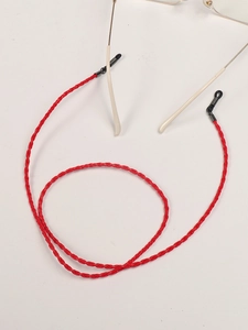 Macro detail of red braided eyewear strap with metal buckle and adjustable silicone loop