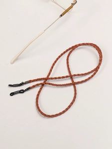 Detail of brown braided leather eyewear strap with silver metal adjustable buckles