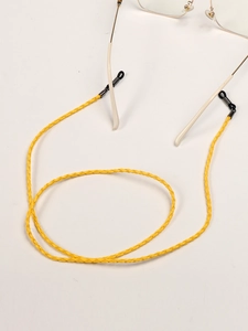 Macro shot of bright yellow braided glasses strap with adjustable black rubber loop ends