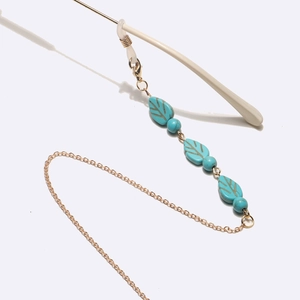 Golden punk eyewear chain with turquoise leaves and non-slip rubber loops on white background