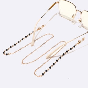 Lunettes dorées avec chaîne en cristal noir et embouts de branches blanc crème
