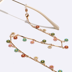 Handmade gold metal glasses chain featuring colorful daisy flower charms and silicone loops