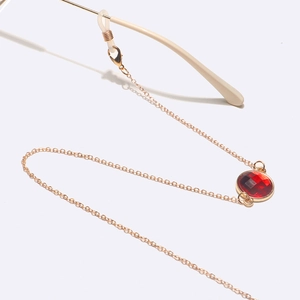 Chaîne à lunettes dorée avec pendentif cristal rouge rond et boucles en silicone