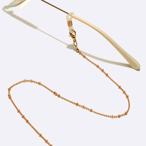 Elegant gold beaded eyewear chain with non-slip silicone loops on a minimalist frame