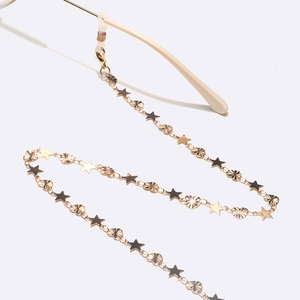 Golden eyewear chain with star and moon charms on a white background with sunglasses