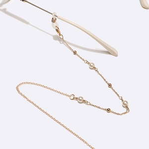 Chaîne de lunettes dorée avec perles élégantes et boucles antidérapantes sur fond blanc