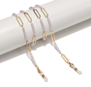 Golden metal eyewear chain with pearls and oval links on white display stand
