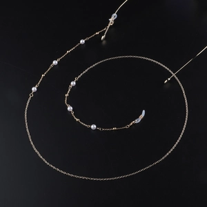 Chaîne de lunettes élégante en métal doré avec perles et embouts silicone sur fond noir