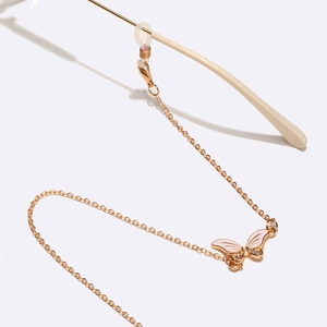 Chaîne à lunettes dorée avec pendentif papillon en strass et perles blanches