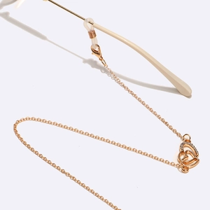 Golden eyeglass chain with sparkling rhinestone heart pendant and pearl details