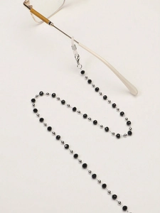 Détail de perles de cristal noir facettées et d'espaceurs argentés sur une chaîne à lunettes