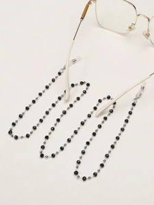 Détail de perles en cristal noir et billes argent sur une chaîne de lunettes