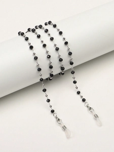Détail de perles noires facettées et de perles en argent sur une chaîne de lunettes chic