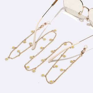 Golden metal eyewear chain with white daisy charms and adjustable rubber loops