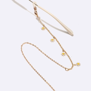 Golden handmade glasses chain featuring white daisy charms and adjustable silicone loops