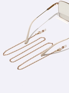 Chaîne de lunettes fine dorée en métal avec boucles antidérapantes sur fond blanc