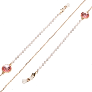 Detail der goldenen Brillenkette mit weißen Perlen und rosa facettierten Edelsteinen