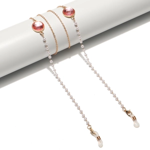 Elegante goldene Brillenkette mit weißen Perlen und rosa Kristallen auf Display