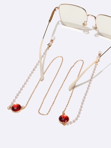 Goldene Brillenkette mit weißen Perlen und roten Kristallen an Brillen mit quadratischem Rahmen