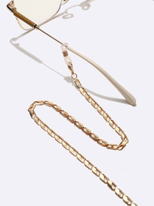 Chaîne de lunettes dorée en métal à maillons ovales avec boucles en silicone sur blanc