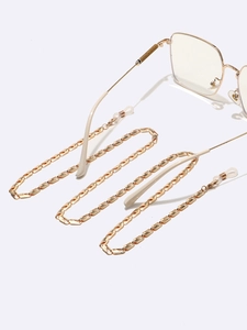 Chaîne à lunettes dorée en métal avec boucles en silicone antidérapantes sur fond blanc