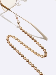Golden heart-shaped metal glasses chain with non-slip silicone loops on white background