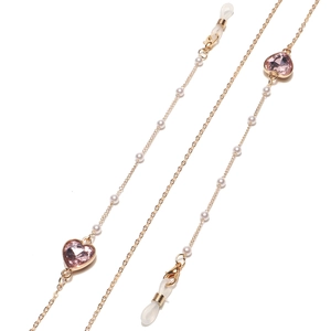 Détail de chaîne dorée avec cœurs en cristal rose et perles blanches pour lunettes