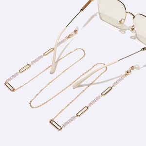 Chaîne à lunettes dorée avec perles roses et cadres rectangulaires sur fond blanc