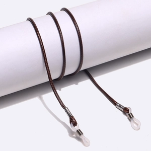 Braided brown eyewear strap with silver metal sleeves and clear silicone ends on white stand