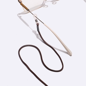 Minimalist dark brown braided eyewear strap with silicone loops on glasses