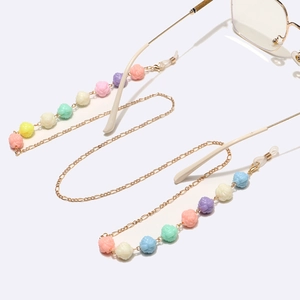 Golden eyewear chain with colorful resin roses and adjustable silicone loops on white background